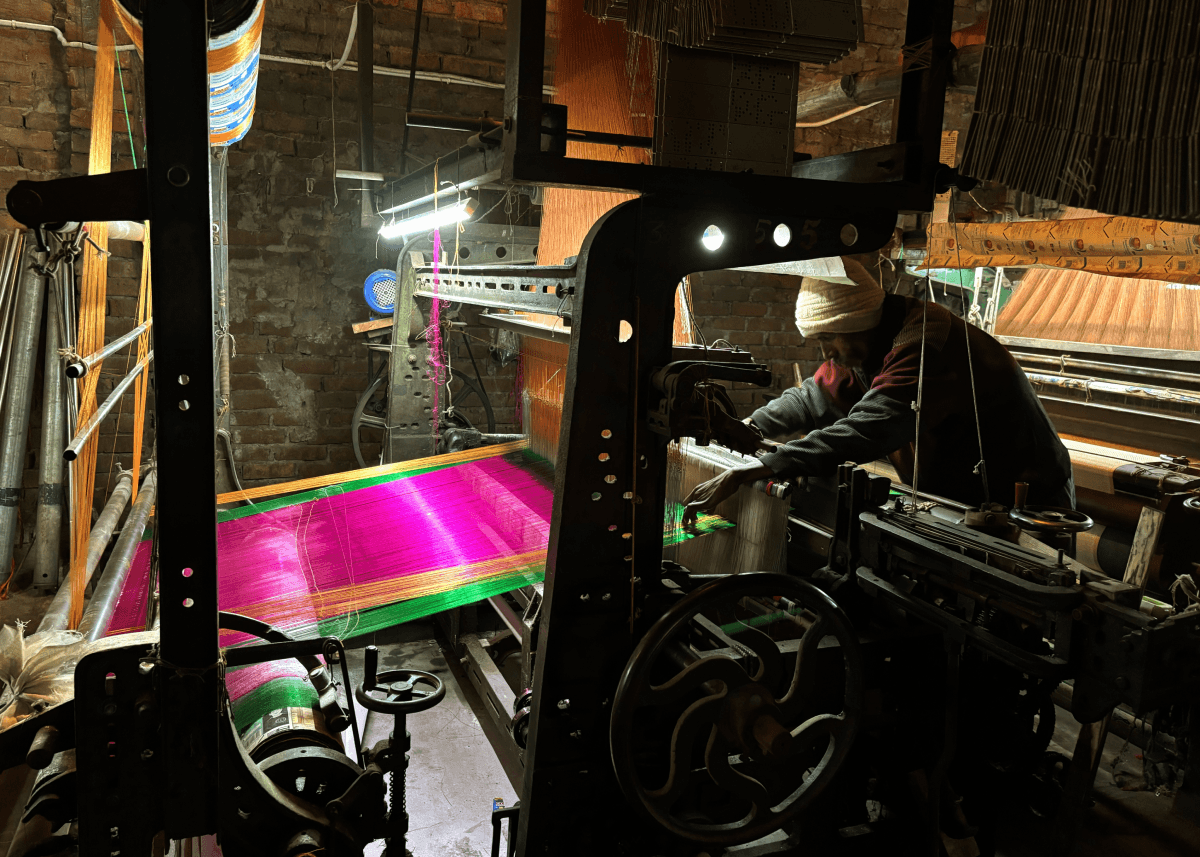 Artisan addressing a flaw on a power loom